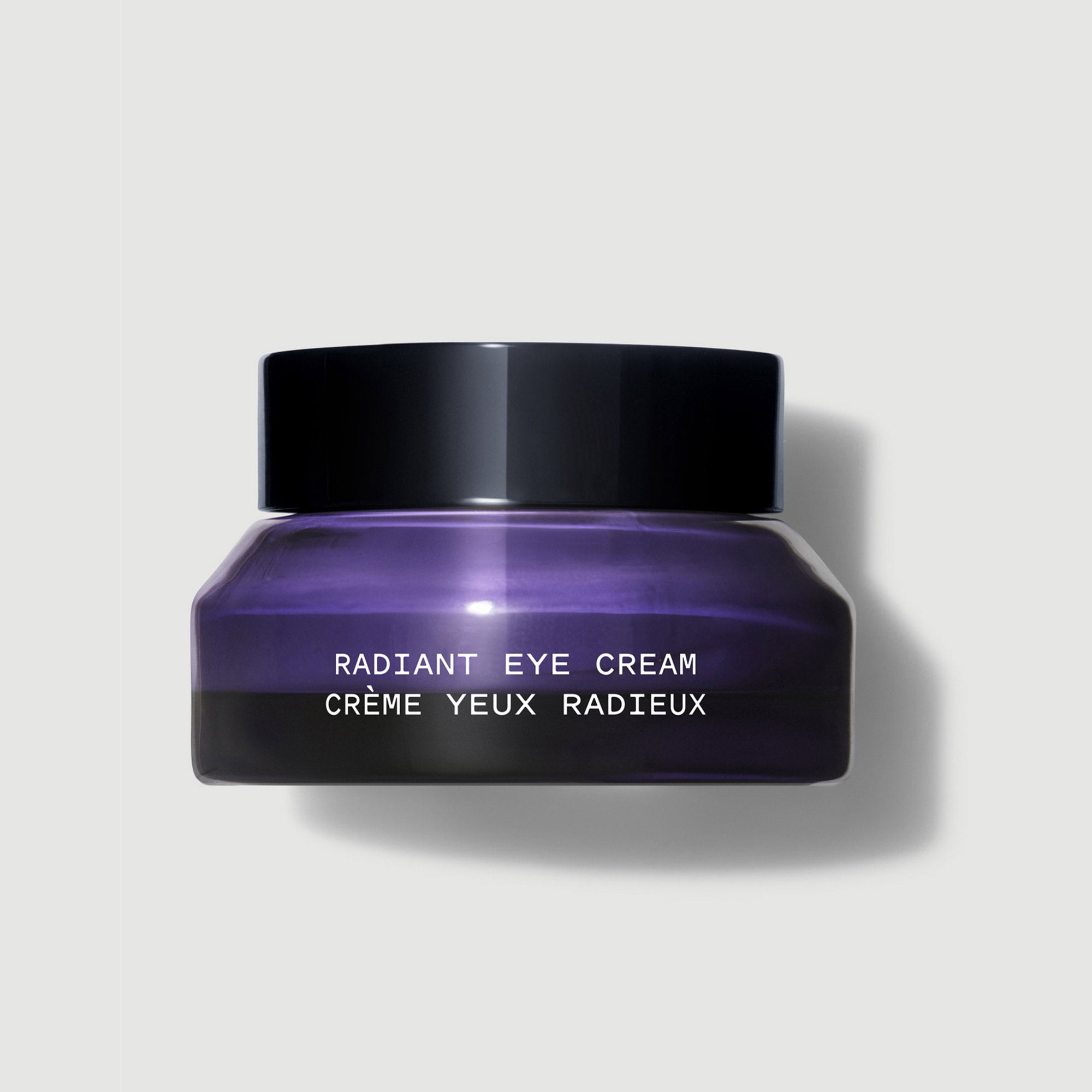 Purple jar of Radiant Eye Cream with black lid on a light gray background