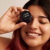 Model holding Radiant Eye Cream to eye