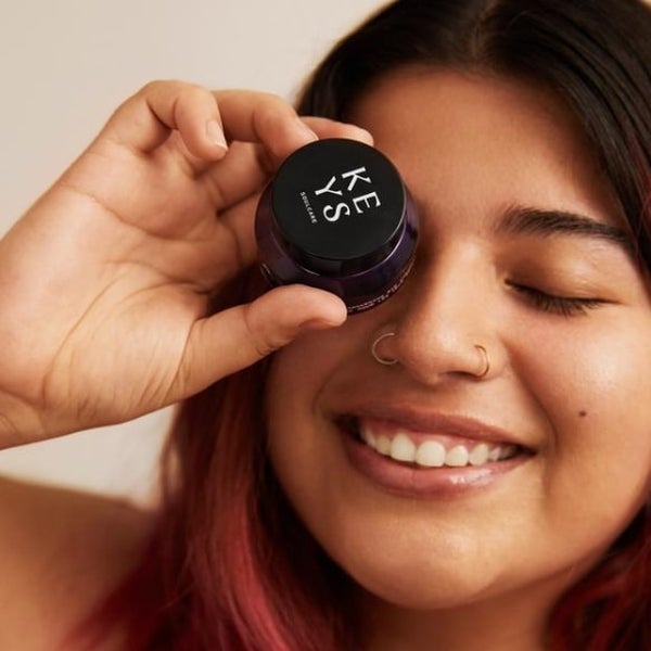 Model holding Radiant Eye Cream to eye